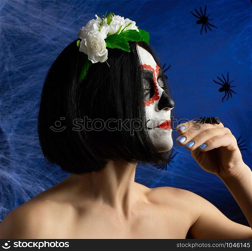 adult beautiful girl with traditional mexican death mask. Calavera Catrina. Sugar skull makeup. girl dressed in a wreath of white roses