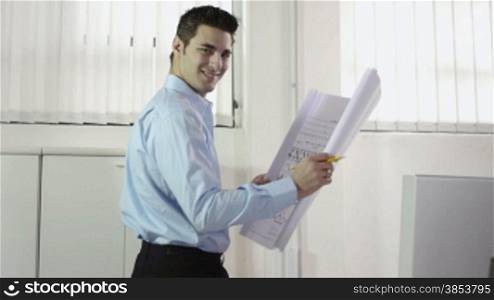 Adult caucasian male architect examining blueprints