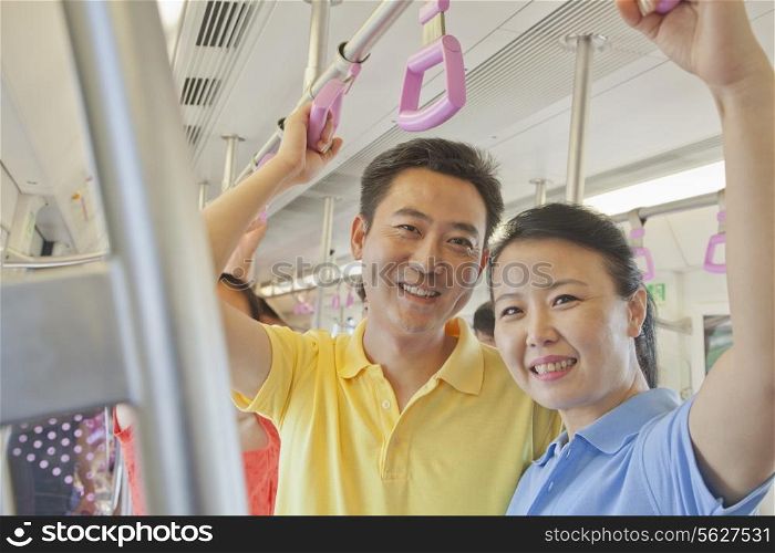 Adult couple standing in the subway and smiling, portrait