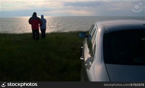 Adult couple traveling to the sea shore by car at sunset