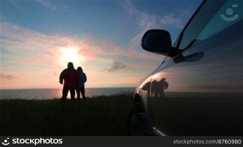 Adult couple traveling to the sea shore by car at sunset