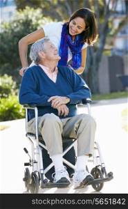 Adult Daughter Pushing Senior Father In Wheelchair