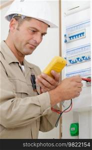 adult electrician builder working with fuseboard