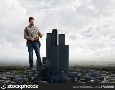 Adult engineer man. Builder man in checked shirt with tool belt on waist