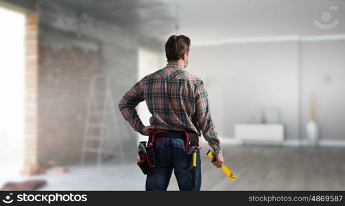 Adult engineer man. Builder man in checked shirt with tool belt on waist. Mixed media