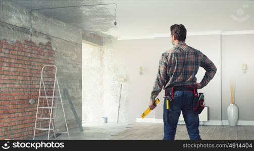 Adult engineer man. Builder man in checked shirt with tool belt on waist. Mixed media