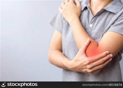 adult female with her muscle pain on gray background. Woman having elbow ache due to lateral epicondylitis or tennis elbow. injuries and medical concept