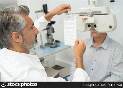 adult male doctor near with ophthalmic equipment
