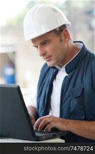 adult male engineer managing process with laptop