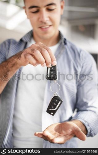 adult male holding car keys