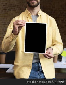 adult male holding tablet office