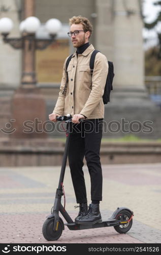 adult male posing with electric scooter 2