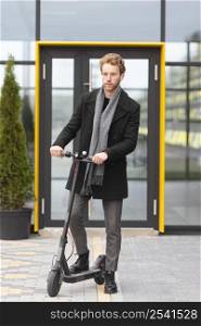 adult male posing with electric scooter