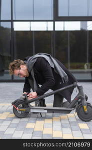 adult male repairing his electric scooter