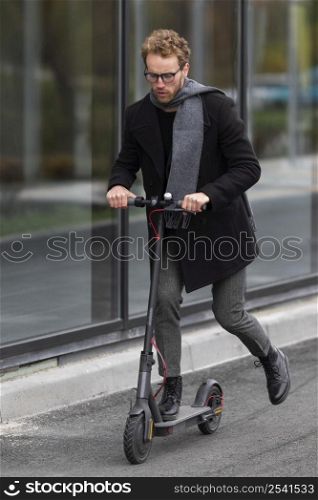 adult male riding his electric scooter