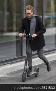 adult male riding his electric scooter