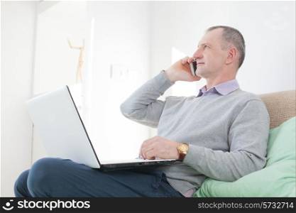 Adult man calling by smartphone at home