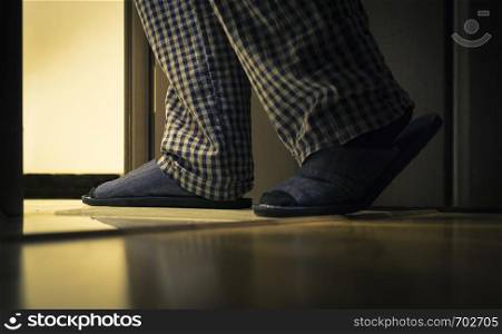 Adult man in pijamas and slippers walks to a bathroom at the night. Men's healths concept. Adult man in pijamas walks to a bathroom at the night. Men's healths concept