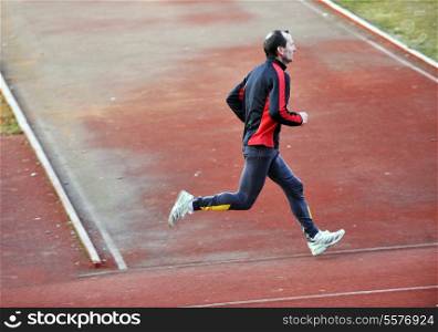 adult man running on athletics track and representing healthy and recreation concept