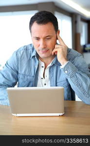 Adult man surfing on internet at home