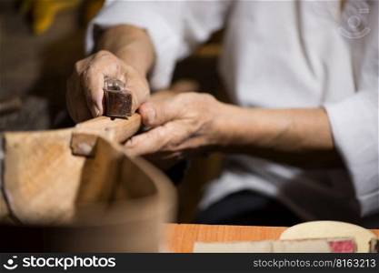adult master restores old musical instruments. wood carving. restoration of musical instruments