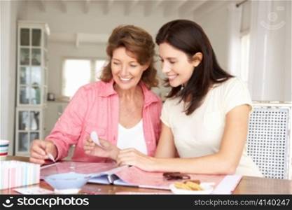 Adult mother and daughter scrapbooking
