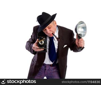 adult news photographer in a costume of the last century fashion and a wide-brimmed hat with an old camera and flash diligently takes a photo