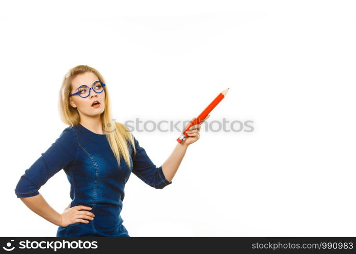 Adult person pensive serious blonde student girl or business woman female teacher wearing nerdy glasses holding big red pencil. Studio shot on white.. Serious woman holds big pencil in hand