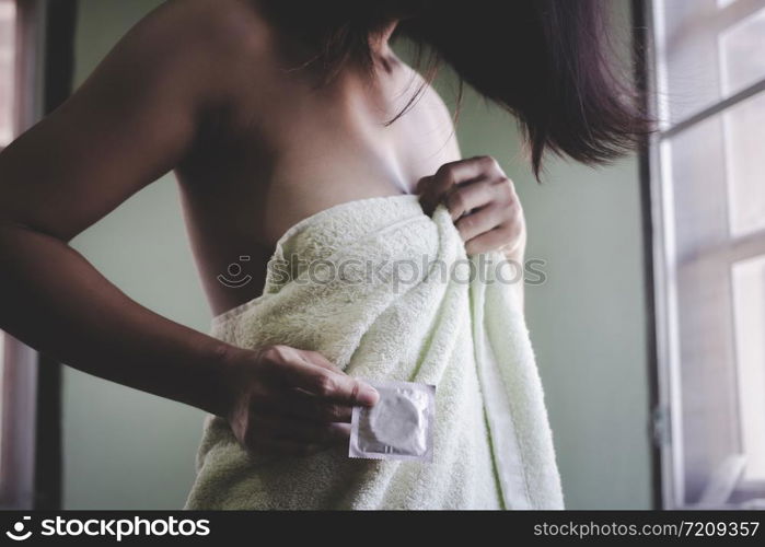 Adult sexy woman prepare a condom for use in safe sex to protect from disease aids