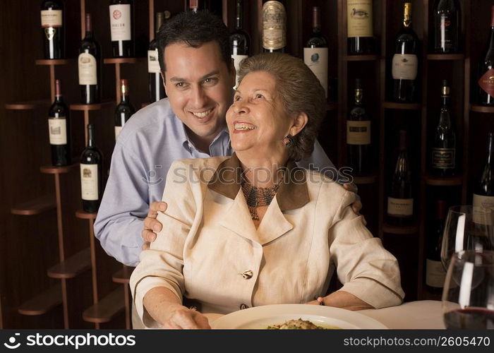 Adult son and mother dining in restaurant