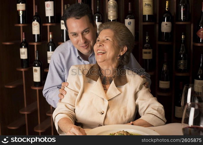 Adult son and mother dining in restaurant