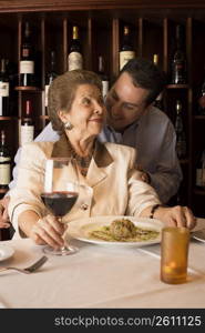 Adult son and mother dining in restaurant