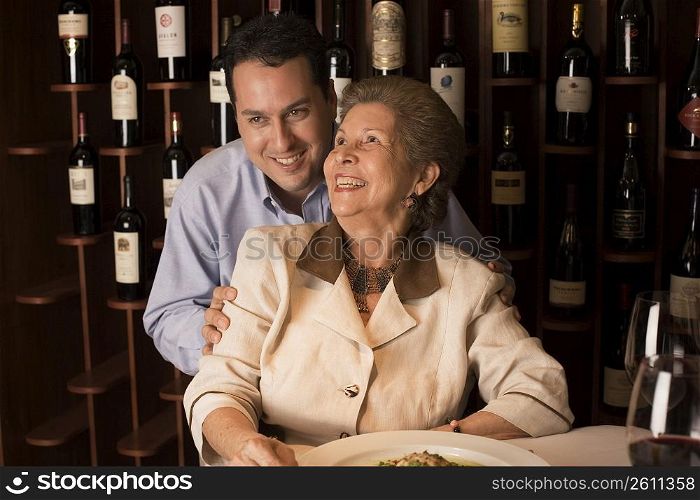 Adult son and mother dining in restaurant