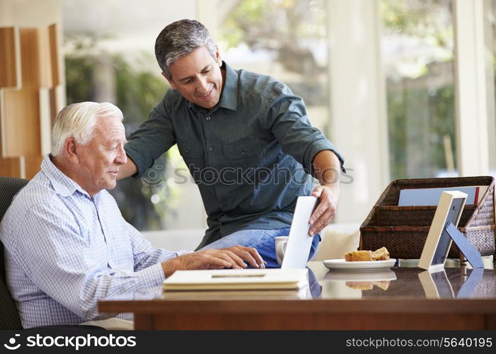 Adult Son Helping Father With Laptop