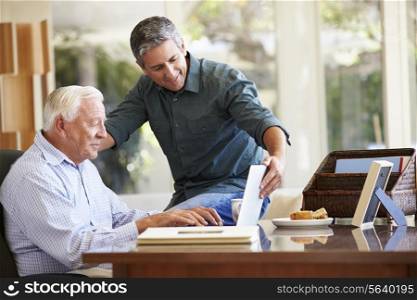 Adult Son Helping Father With Laptop