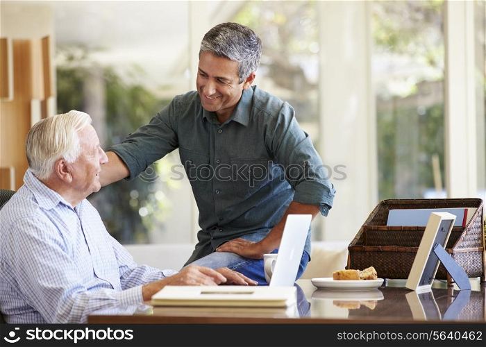 Adult Son Helping Father With Laptop
