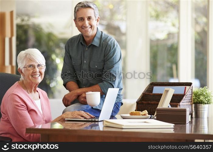Adult Son Helping Mother With Laptop