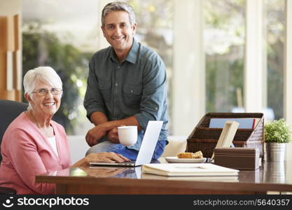 Adult Son Helping Mother With Laptop