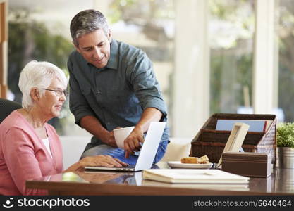 Adult Son Helping Mother With Laptop