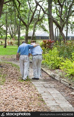 Adult son walking his senior grandfather in the park. Vertical view with room for text.