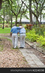 Adult son walking his senior grandfather in the park. Vertical view with room for text.