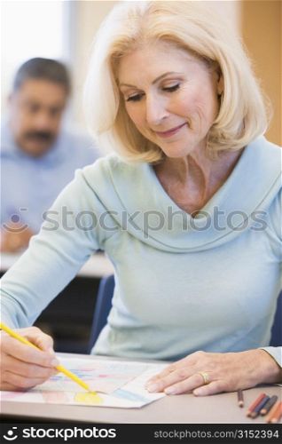 Adult student in class drawing picture (selective focus)