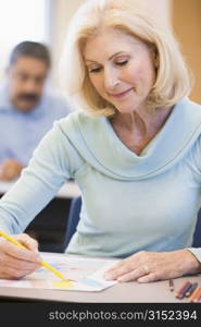 Adult student in class drawing picture (selective focus)