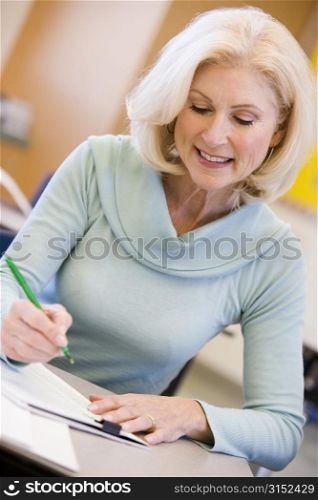 Adult student in class taking notes