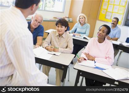 Adult students in class with teacher (selective focus)