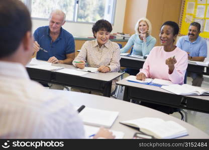 Adult students in class with teacher (selective focus)