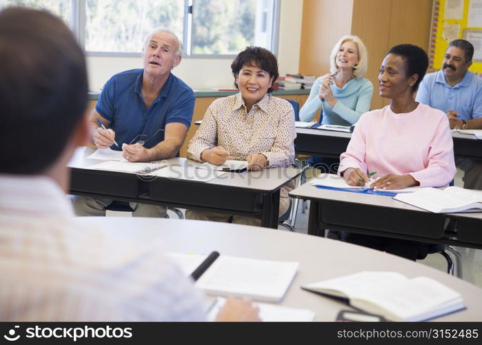 Adult students in class with teacher (selective focus)