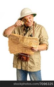 Adult tourist in tropical pith helmet and protective clothing looks into a magnifying glass on an old map.. tropical helmet tourist