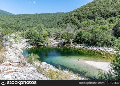 Adult woman in a Pure and fresh water natural pool of Travu River, Corsica, France, Europe. Pure and fresh water flowing of Travo River, Corsica, France