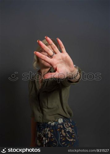 Adult woman shows stopping or prohibiting gesture with hand. gesture no girl